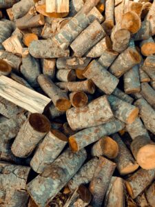 Close-up shot of stacked firewood logs, showcasing natural textures and patterns outdoors.