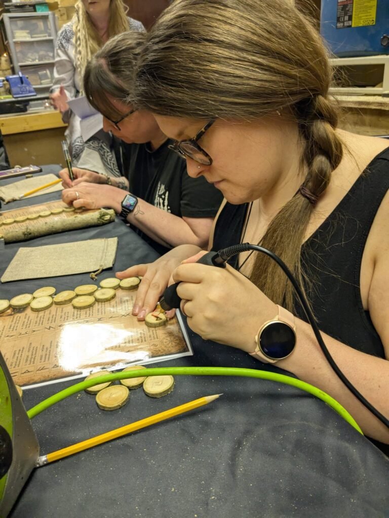 Participant creating wooden runes during an Elderwood community workshop